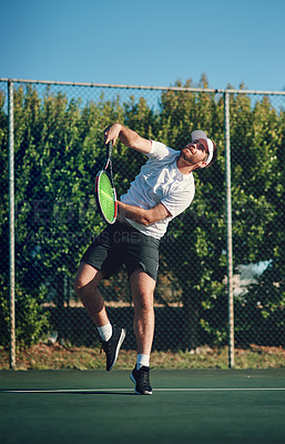 Buy stock photo Shot of a sporty young man playing tennis on a tennis court