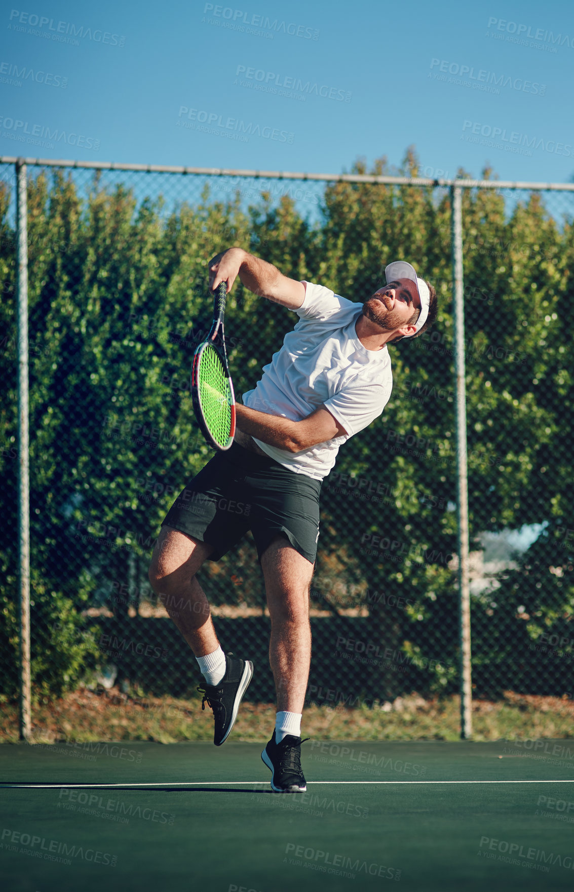 Buy stock photo Shot of a sporty young man playing tennis on a tennis court