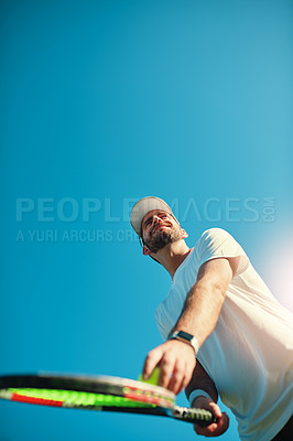 Buy stock photo Low angle shot of a sporty young man playing tennis