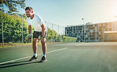 Buy stock photo Shot of a sporty young man holding his knee in pain while playing tennis on a tennis court