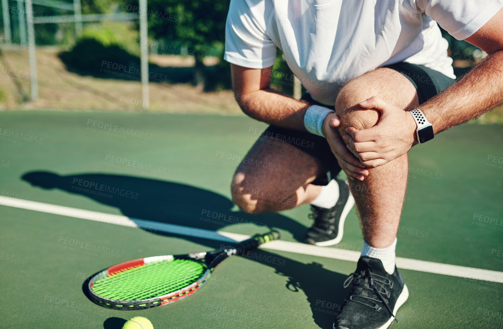 Buy stock photo Closeup shot of an unrecognisable man holding his knee in pain while playing tennis on a tennis court