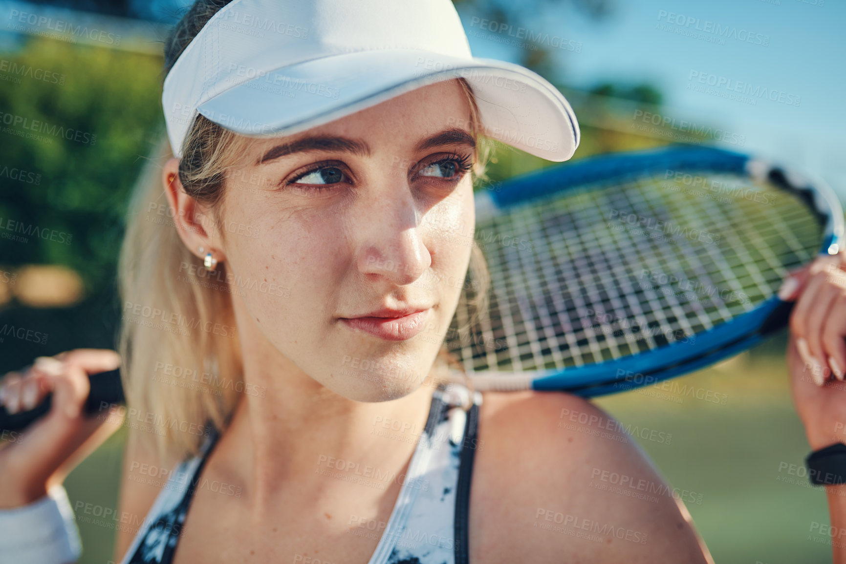 Buy stock photo Shot of a sporty young woman standing on a tennis court with a tennis racket