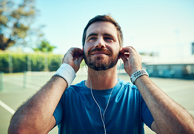 Buy stock photo Tennis court, sports and man thinking with earphones on practice or training break. Male person, outdoor and relax with smile with streaming service for music or audio at tournament or match