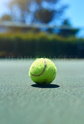 Buy stock photo Cropped shot of a tennis ball on an empty court during the day
