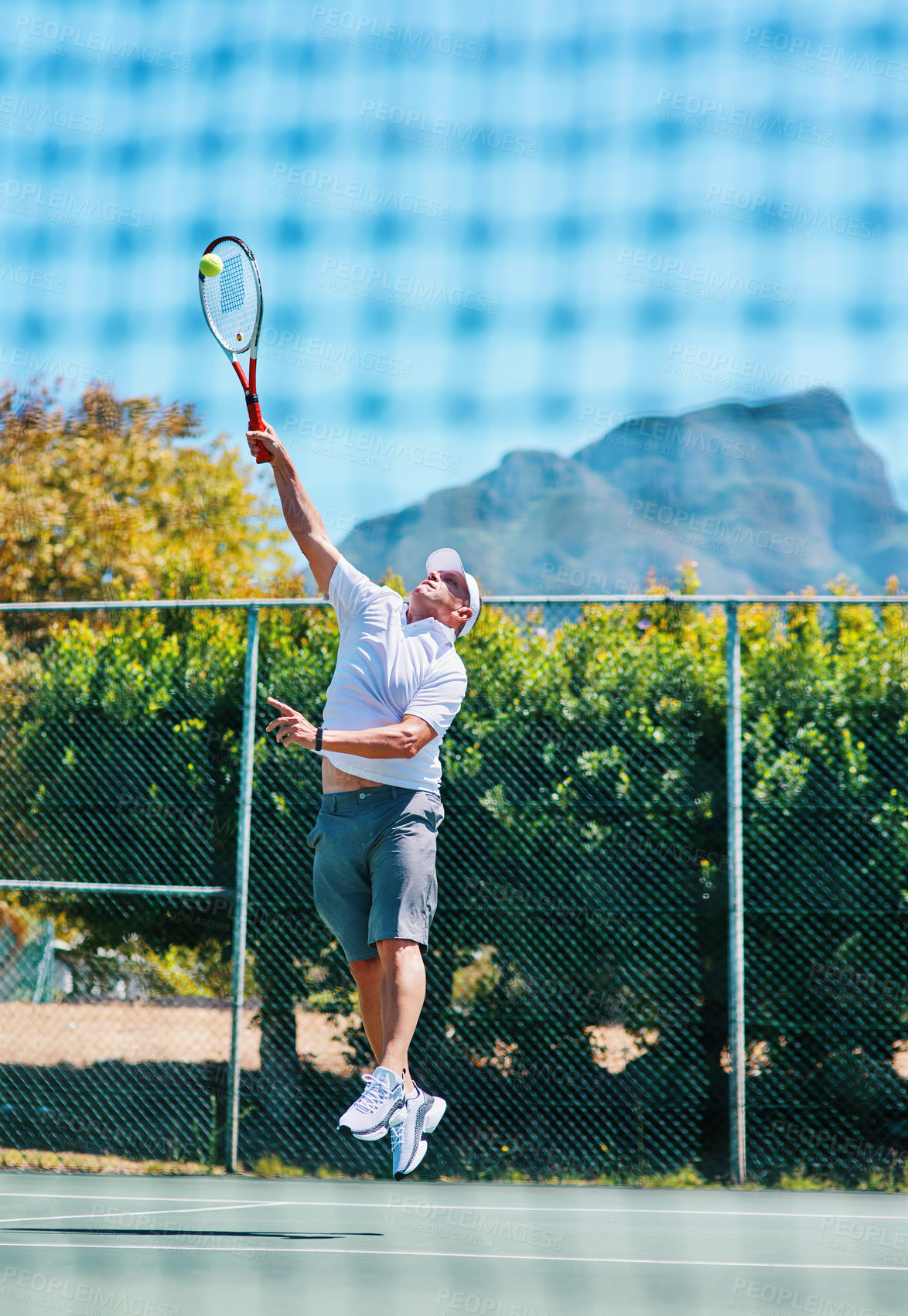 Buy stock photo Full length shot of a handsome mature man playing tennis alone on a court during the day