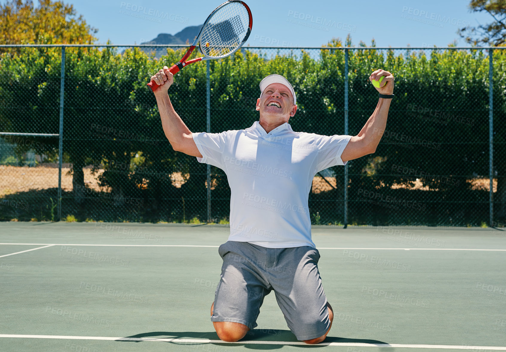Buy stock photo Cropped shot of a handsome mature man celebrating a win while playing tennis during the day