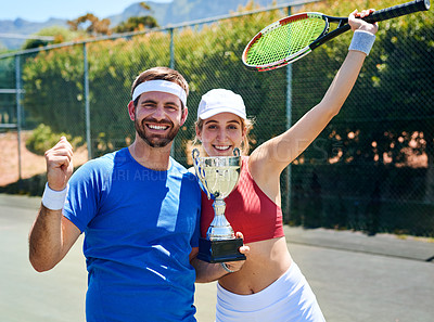 Buy stock photo Cropped portrait of two young sportspeople standing together and holding a trophy after winning a tennis match