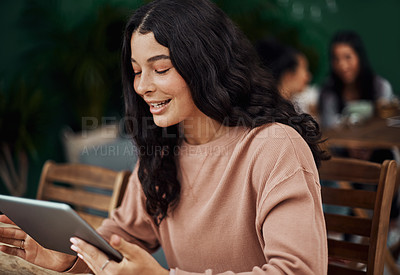 Buy stock photo Shot of a beautiful young woman using a digital tablet at a cafe