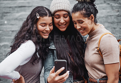 Buy stock photo Cropped portrait of an attractive group of sisters standing together and taking a selfie with a cellphone in the city