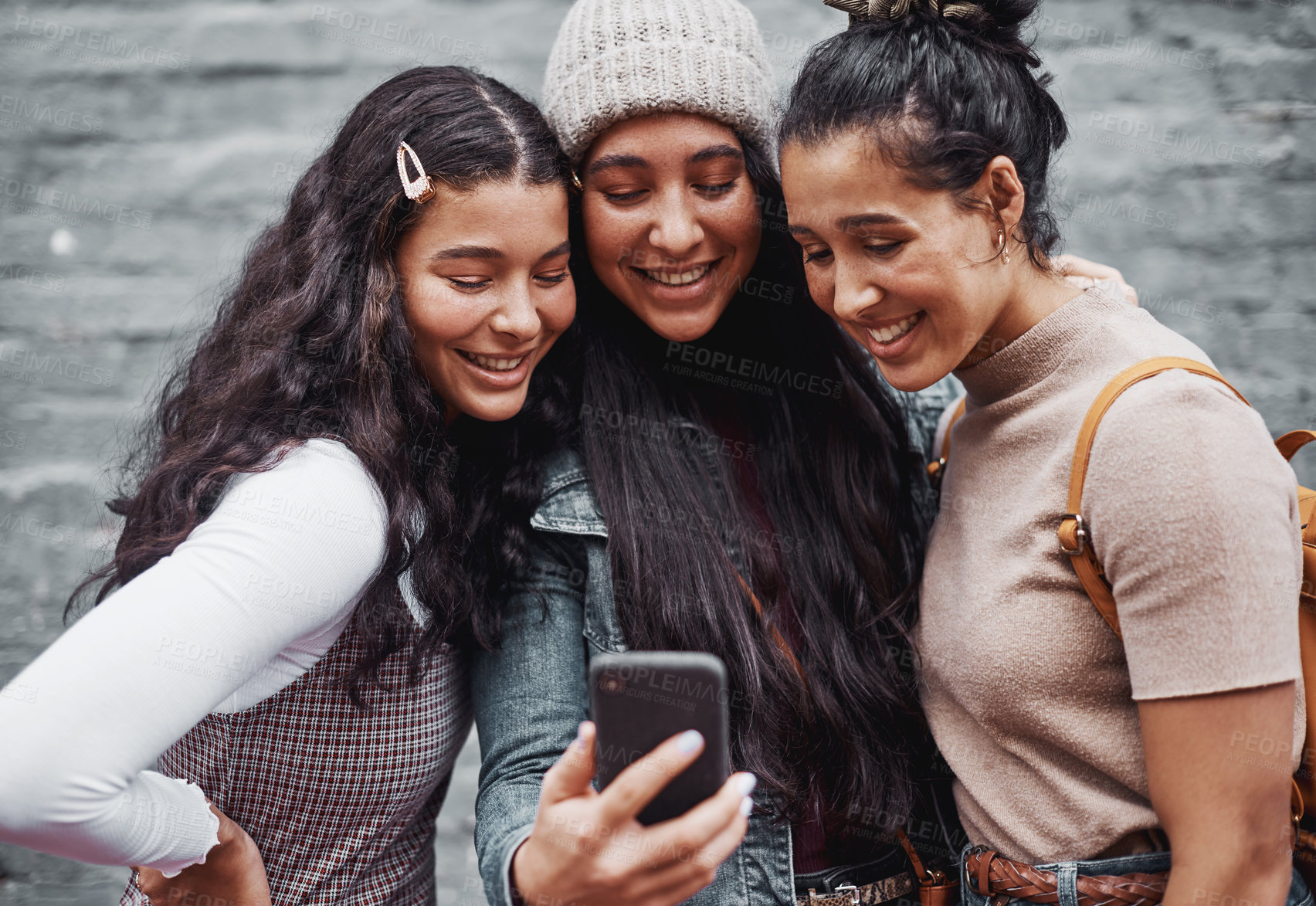 Buy stock photo Cropped portrait of an attractive group of sisters standing together and taking a selfie with a cellphone in the city