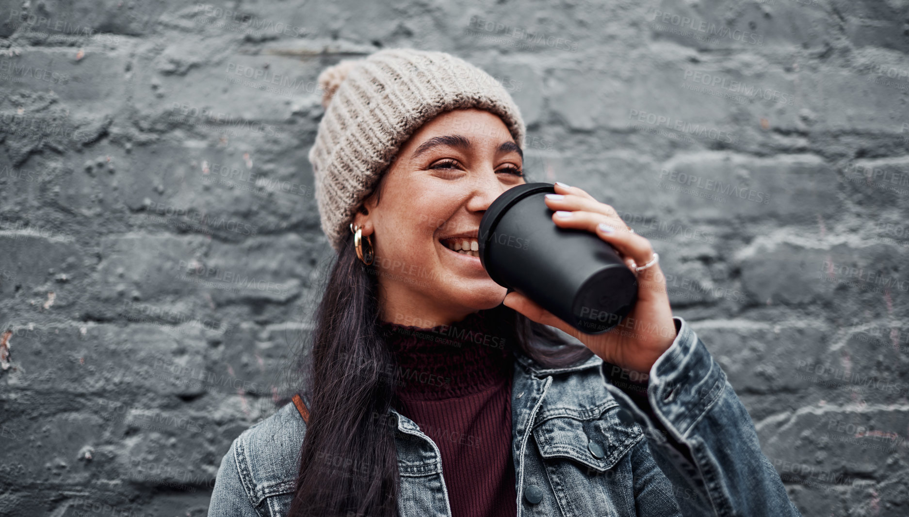 Buy stock photo Cropped shot of an attractive teenage girl standing against a gray wall in the city and drinking coffee