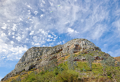 Buy stock photo A photo of Lions Head and surroundings in Cape Town. Backdrop of rocky mountain with green vegetation and trees against blue sky filled with small wispy clouds. Barren landscape of natural wonder