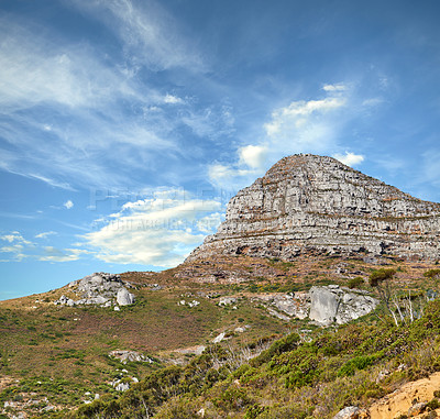 Buy stock photo Landscape view of Lions Head mountain with clouds covering the peak against a blue sky and copy space in Cape Town, South Africa. Wild, rough hiking terrain in popular tourism destination and nature