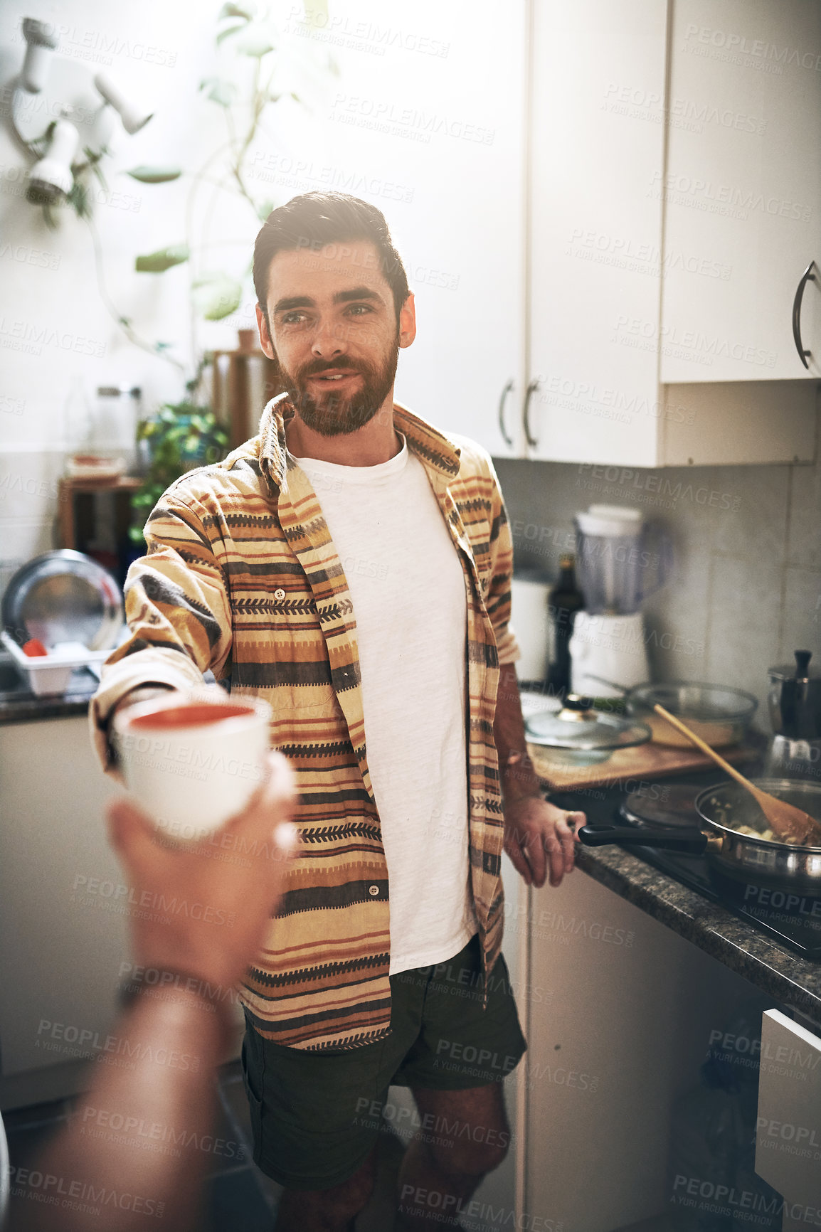 Buy stock photo POV shot of an unrecognizable man receiving a cup of coffee inside of the kitchen during the day
