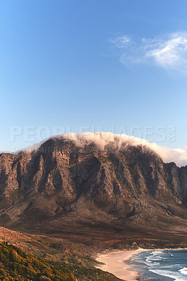 Buy stock photo Cropped shot of a mountain range near the sea during a clear day outdoors