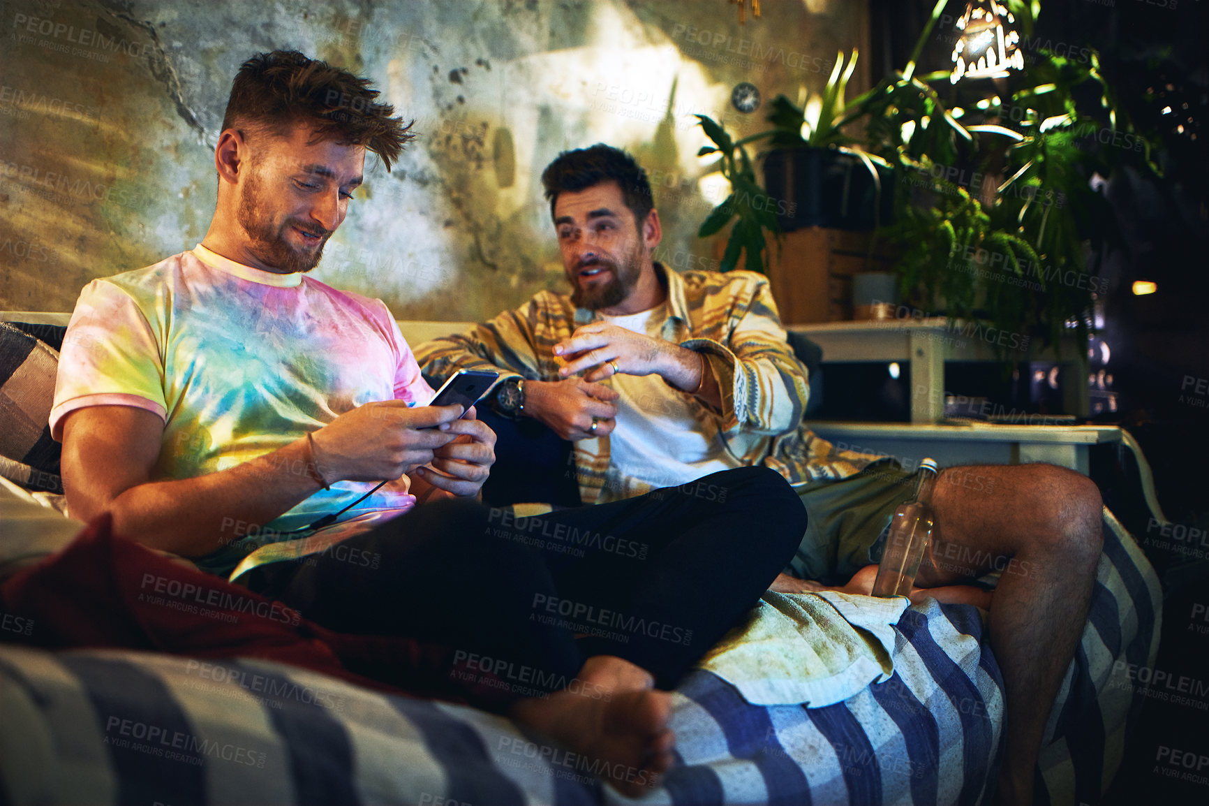 Buy stock photo Night, men and friends on sofa with phone, social media on mobile app or bonding together in home. Weekend, relax and people on smartphone, online chat or video streaming on couch in dark living room