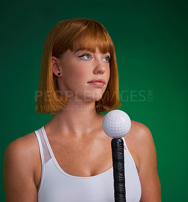 Buy stock photo Cropped shot of an attractive young sportswoman standing and posing with hockey equipment against a green studio background