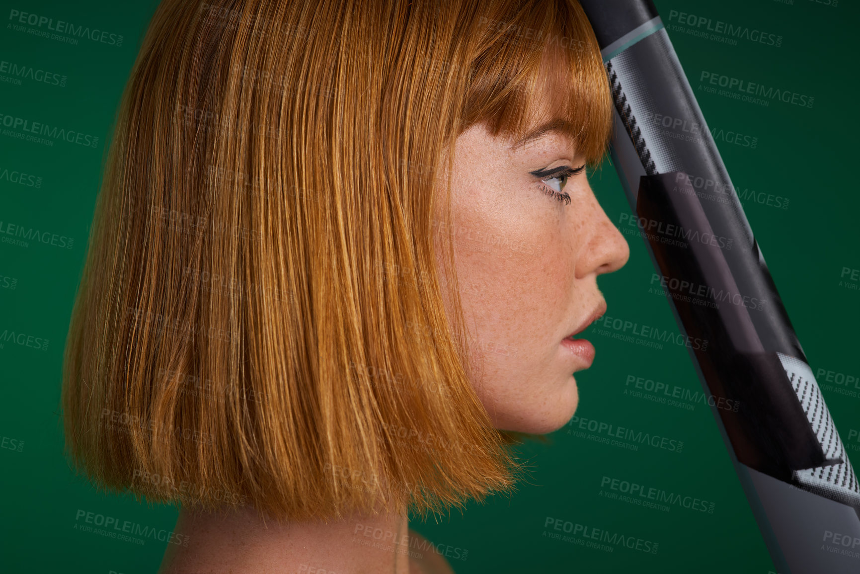 Buy stock photo Cropped shot of an attractive young sportswoman standing alone and posing with hockey stick against a green studio background