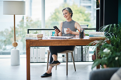 Buy stock photo Shot of a businesswoman having coffee while using her cellphone in her office