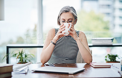 Buy stock photo Shot of a mature businesswoman having coffee in her office