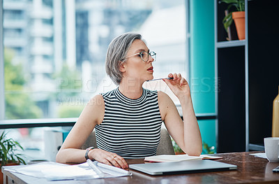 Buy stock photo Shot of a mature businesswoman looking thoughtful while sitting at her desk