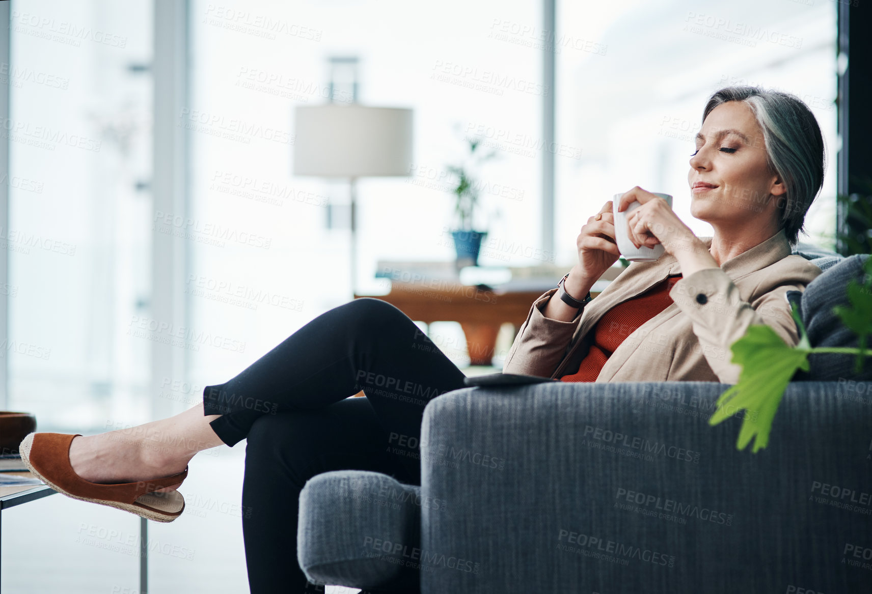 Buy stock photo Coffee, relax and mature businesswoman with drink in office for morning routine or breakfast beverage. Caffeine, comfort or calm realtor on sofa with herbal tea for resting, scent and smell of aroma