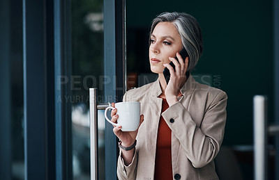 Buy stock photo Cropped shot of an attractive mature businesswoman standing alone and talking on her cellphone while enjoying a cup of coffee