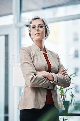 Buy stock photo Cropped portrait of an attractive mature businesswoman standing alone with her arms folded in her home office