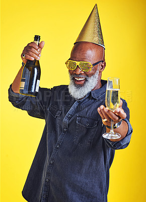 Buy stock photo Portrait of a cheerful senior man celebrating and drinking champagne in studio against a yellow background