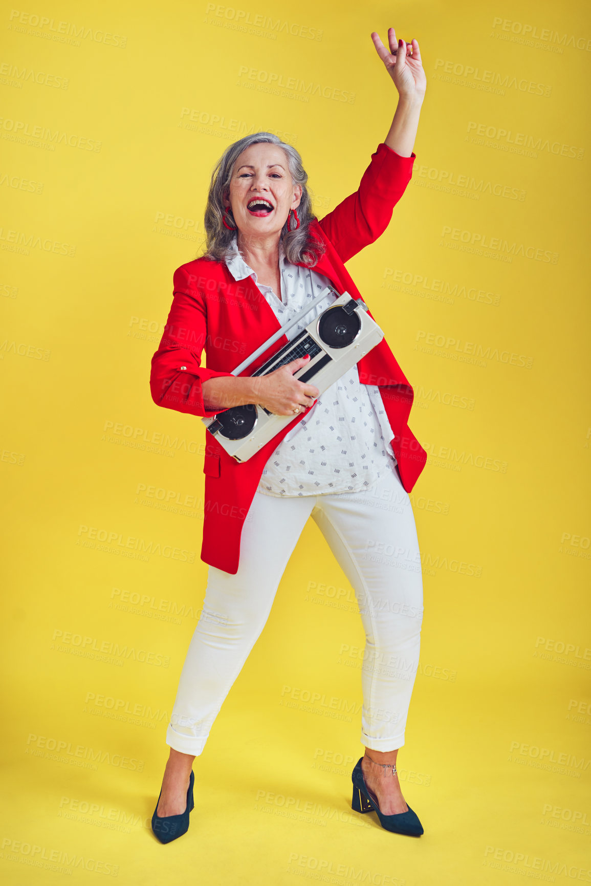 Buy stock photo Full length shot of a funky and stylish senior woman dancing while holding a boombox against a yellow background