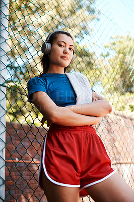 Buy stock photo Portrait of a sporty young woman standing against a fence outdoors