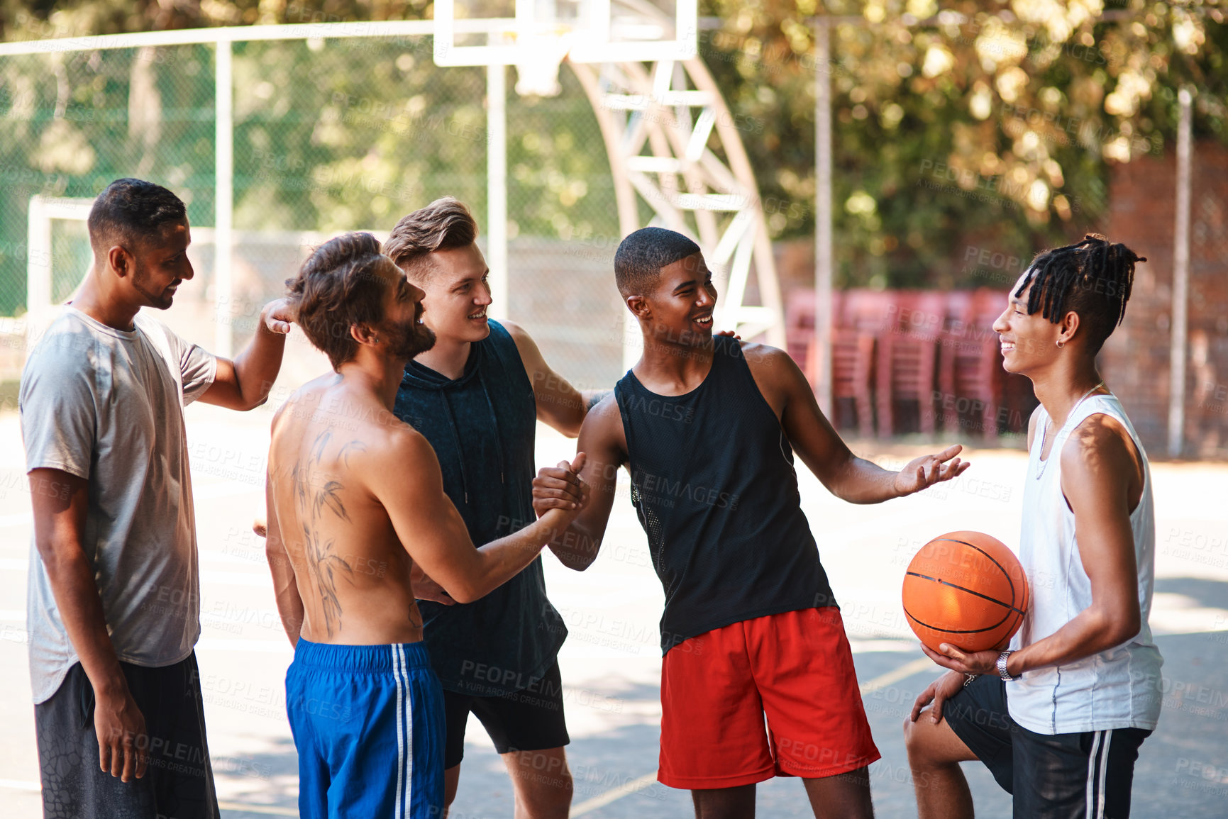 Buy stock photo Shot of a group of sporty young men greeting each other on a basketball court