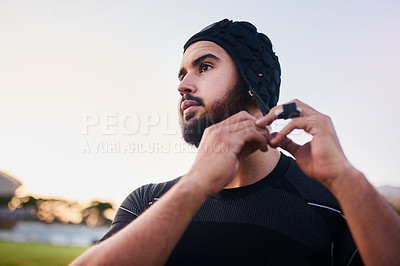 Buy stock photo Man, rugby and adjusting headgear for outdoor, game or challenge for exercise, wellness and fitness. Male person, athlete and recreation facility in scrum cap for match, sport and training in stadium