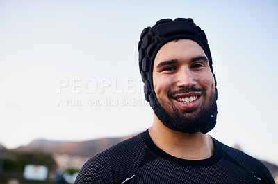 Buy stock photo Cropped portrait of a handsome young sportsman wearing headgear and standing alone during rugby practice during the day