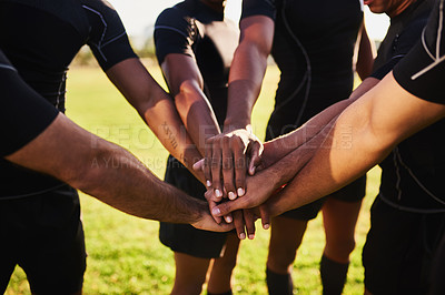 Buy stock photo Cropped shot of an unrecognizable group of sportsmen huddled together with their hands in the middle before playing rugby