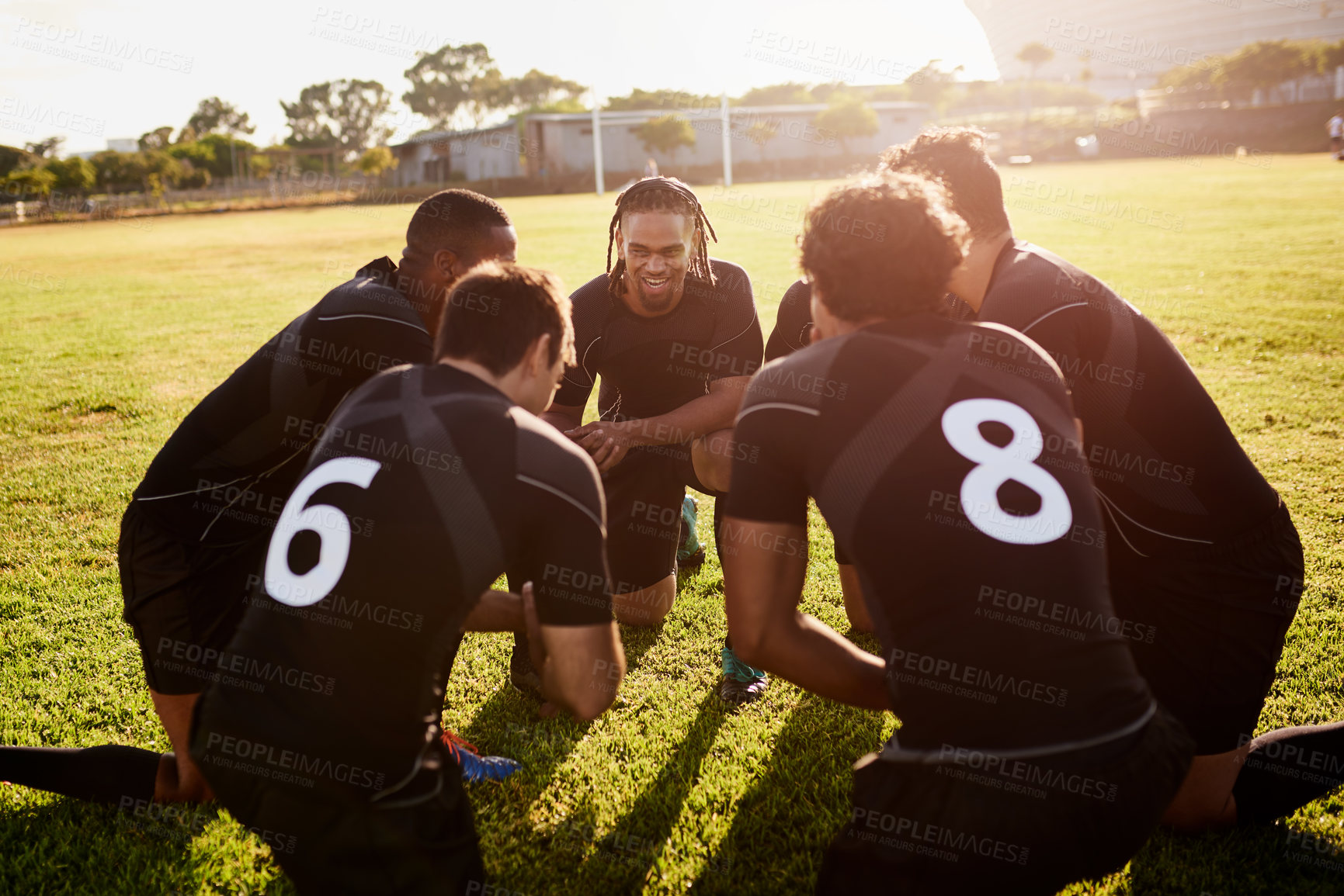 Buy stock photo Cropped shot of a diverse group of sportsmen crouching together before playing rugby during the day