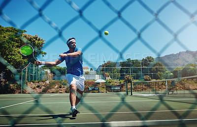 Buy stock photo Full length shot of a handsome young sportsman playing tennis alone on a court during the day