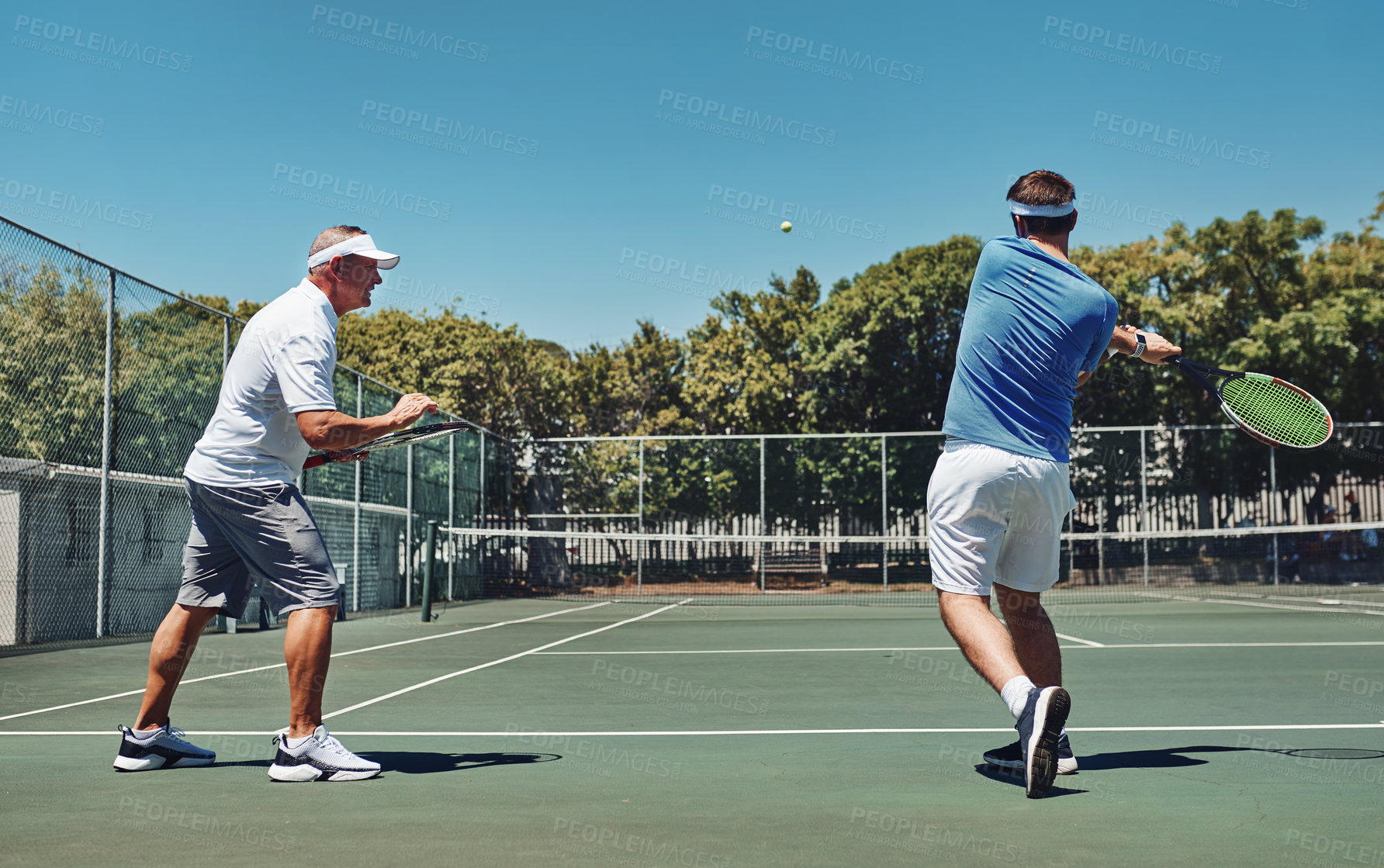 Buy stock photo Full length shot of a handsome mature sportsman coaching a fellow team-mate during a tennis training session