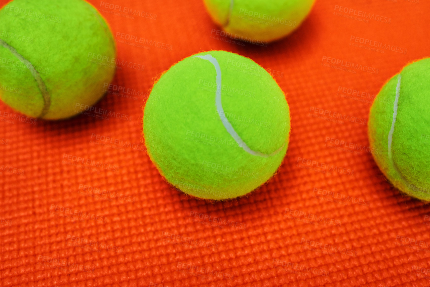 Buy stock photo Closeup of a group of tennis balls placed together on top of an orange background