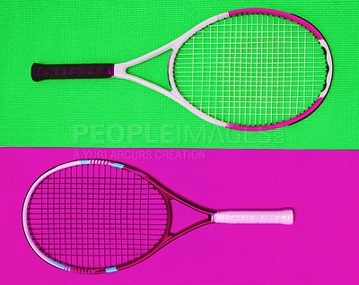 Buy stock photo High angle shot of two tennis rackets placed together on top of a colourful background inside of a studio