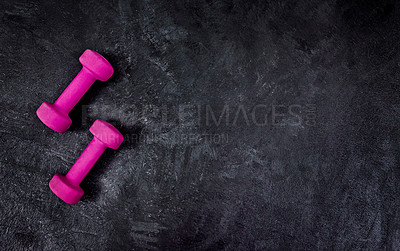 Buy stock photo High angle shot of two lightweight dumbbells placed on a dark background inside of a studio