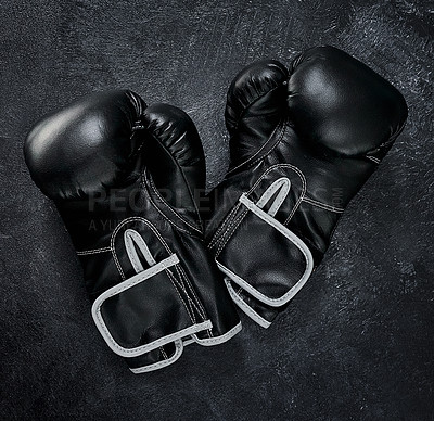 Buy stock photo High angle shot of a pair of boxing gloves placed together on top of a dark background inside of a studio