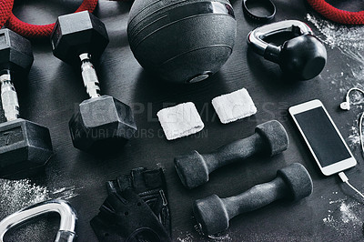 Buy stock photo High angle shot of fitness workout essentials placed on top of a dark background inside of a studio