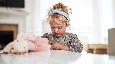Buy stock photo Cropped shot of an adorable little girl standing alone in the living room and playing with her toys at home