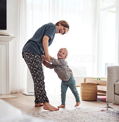 Buy stock photo Full length shot of an attractive young mother and playing with her daughter in the living room at home