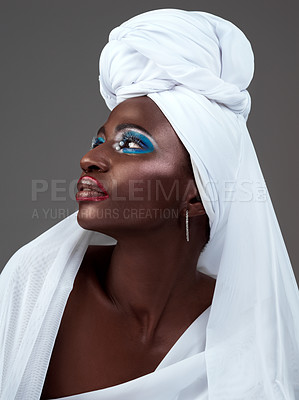 Buy stock photo Young, African and woman in cosmetics or fashion with makeup, traditional clothing and head scarf in studio. Female person, beauty and confident for heritage, pride and culture in grey background