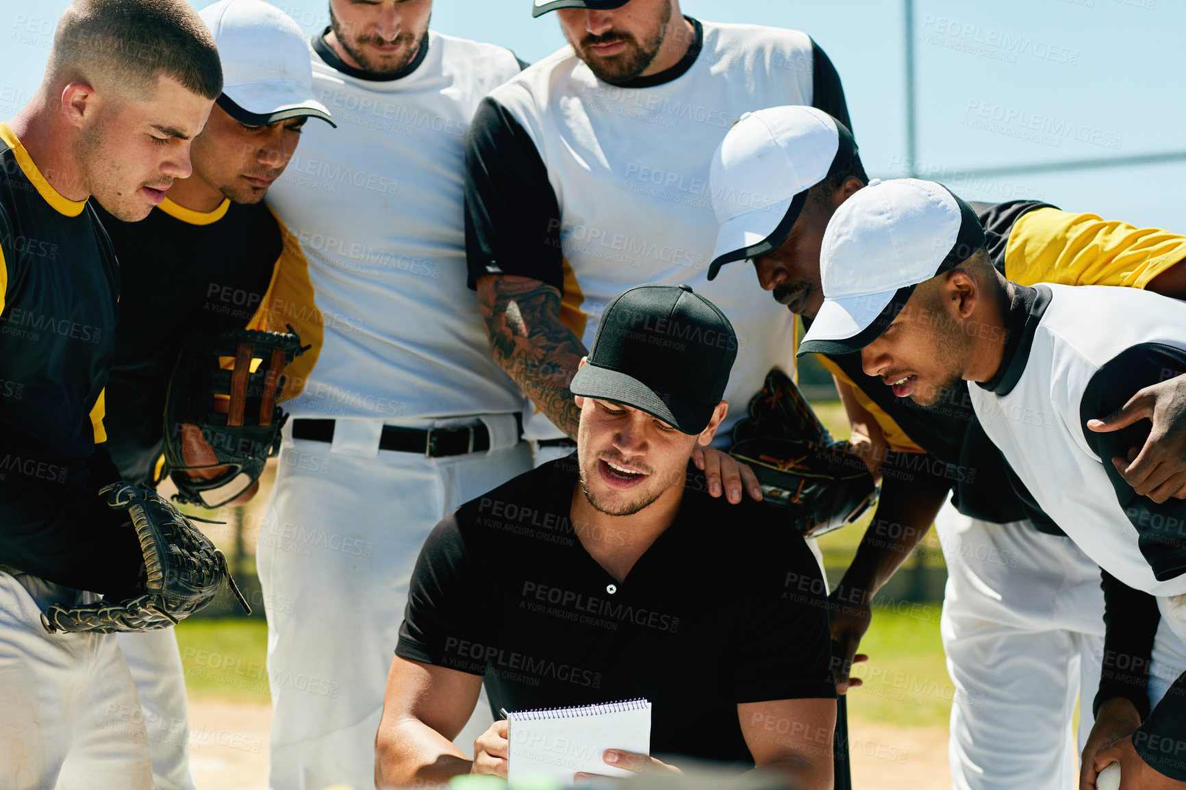 Buy stock photo Cropped shot of a group of young baseball players having a meeting with their coach on the field during the day