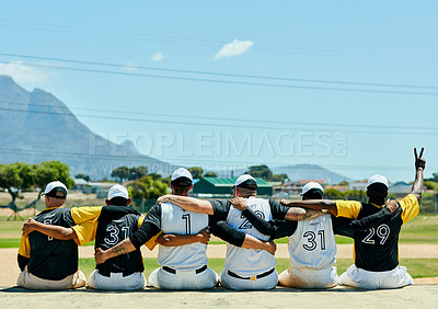 Buy stock photo Rearview shot of a team of unrecognizable baseball players embracing each other while sitting near a baseball field during the day
