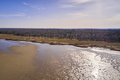 Buy stock photo Dry bush land by the beach with clear sky copy space. Landscape of the mudflat with calm water surface reflection on a sunny day. A peaceful aerial view of Mariager Fjord flow in Jutland
