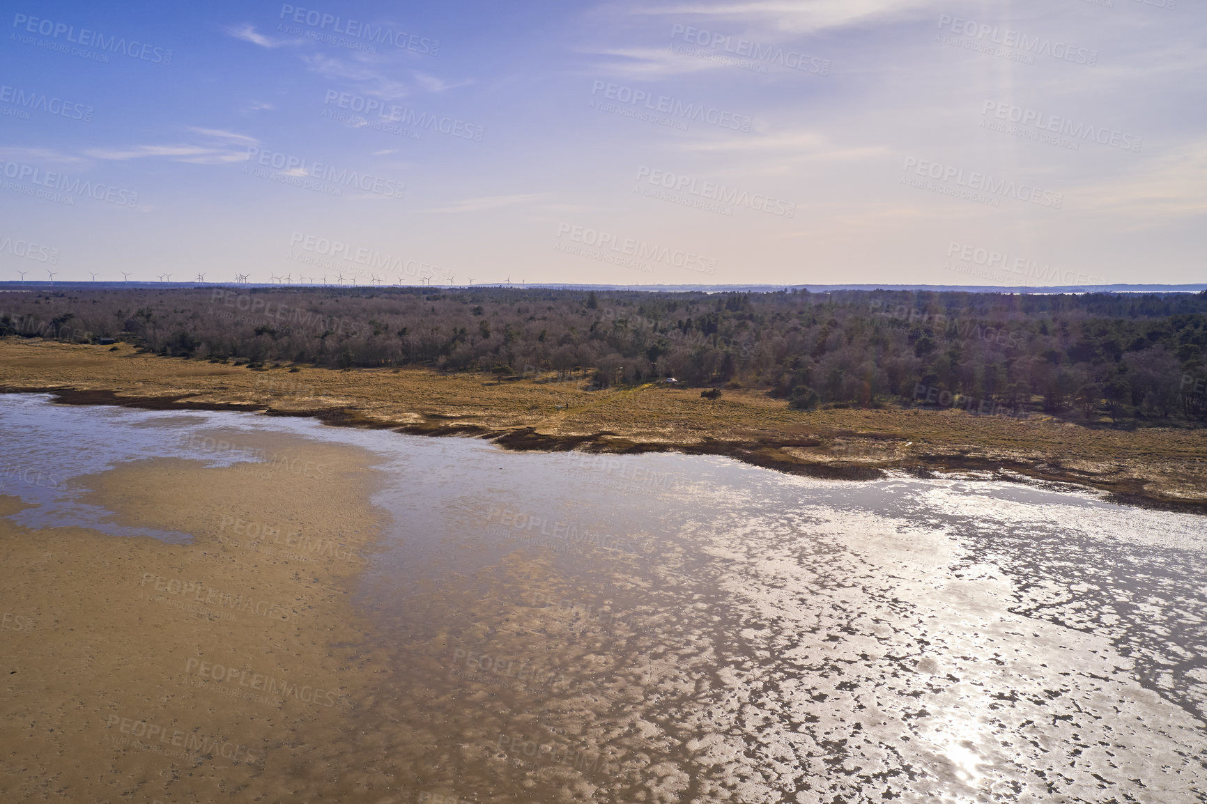 Buy stock photo Dry bush land by the beach with clear sky copy space. Landscape of the mudflat with calm water surface reflection on a sunny day. A peaceful aerial view of Mariager Fjord flow in Jutland